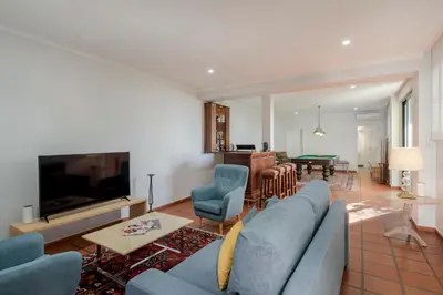 a living room with a blue couch and a tv at OurMadeira - Vista Grande in Caniço