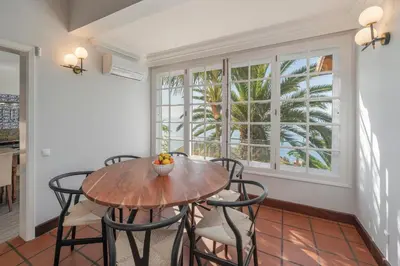 a dining room with a table and chairs and a window at OurMadeira - Vista Grande in Caniço