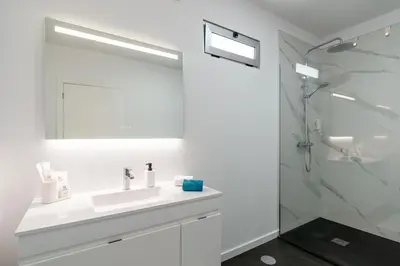 a white bathroom with a sink and a shower at Casa Alan by Rent2u, Lda in Arco da Calheta