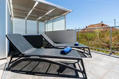 two chairs sitting on top of a patio at Casa Alan by Rent2u, Lda in Arco da Calheta