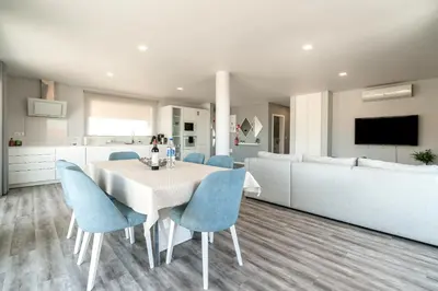 a kitchen and dining room with a table and blue chairs at Casa Alan by Rent2u, Lda in Arco da Calheta