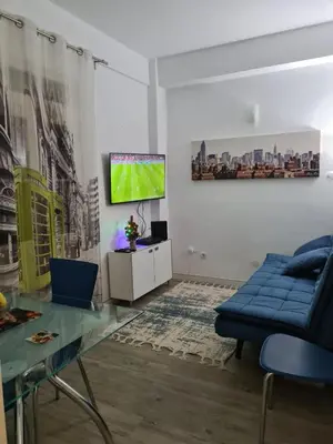a living room with a blue couch and a tv at Machico Centre Comfort in Machico