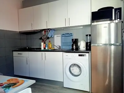 a kitchen with a refrigerator and a washing machine at Machico Centre Comfort in Machico
