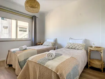two beds in a room with a window at Casa Pico dos Barcelos by LovelyStay in Funchal