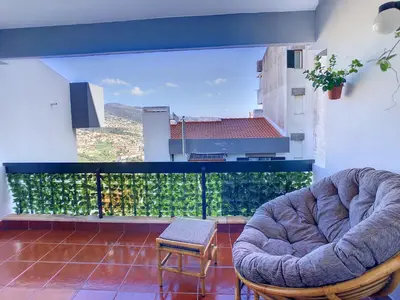 a living room with two chairs and a balcony at Casa Pico dos Barcelos by LovelyStay in Funchal