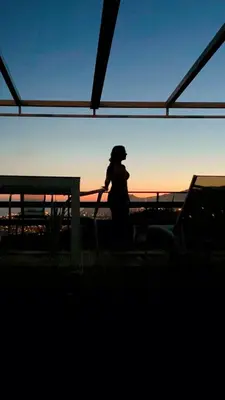 a woman standing next to a fence at sunset at Studio Geek Villa - Open Space - 5m from 5 top attractions - Pool all year round, Dining Pergola, Barbecue - Funchal Matrix Holiday Home in Funchal