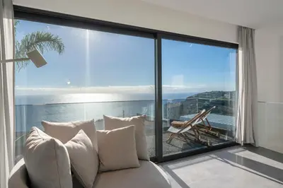 a living room with a couch and a large window at Villa Candelária by An Island Apart in Ribeira Brava