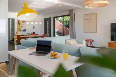 a laptop on a table with a glass of orange juice at Villa Candelária by An Island Apart in Ribeira Brava