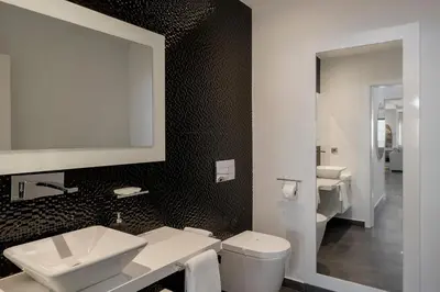 a bathroom with a sink and a toilet and a mirror at Villa Candelária by An Island Apart in Ribeira Brava
