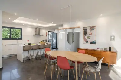 a kitchen and dining room with a wooden table and chairs at Villa Candelária by An Island Apart in Ribeira Brava