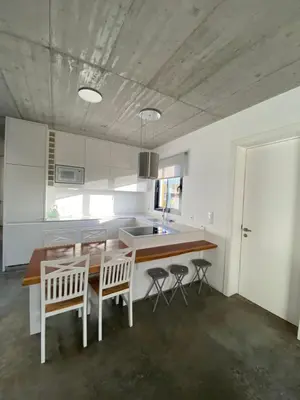 a kitchen with a table and chairs and a sink at CASA DA PITANGA in Jardim do Mar
