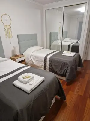 a hotel room with two beds and a mirror at Cristinas 2 Bedroom Apartment Caniço in Caniço
