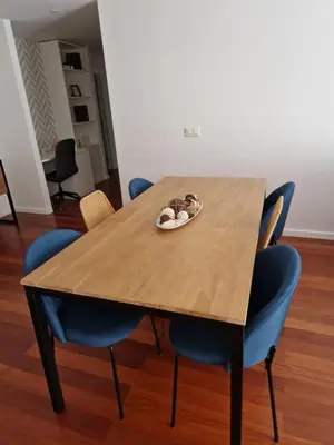 a table with blue chairs and a plate of food on it at Cristinas 2 Bedroom Apartment Caniço in Caniço