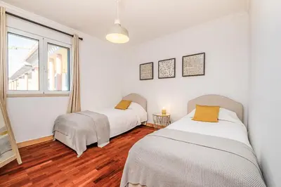 two beds in a room with white walls and wood floors at Pateo do Carmo - By Wehost in Funchal