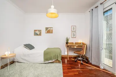 a bedroom with a bed and a desk and a window at Pateo do Carmo - By Wehost in Funchal