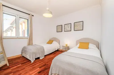 two beds in a white room with a window at Pateo do Carmo - By Wehost in Funchal