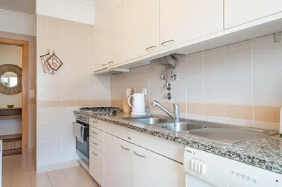 a kitchen with white cabinets and a sink at Pateo do Carmo - By Wehost in Funchal