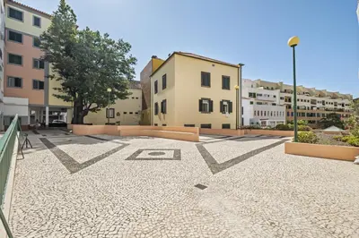 an empty parking lot in a city with buildings at Pateo do Carmo - By Wehost in Funchal