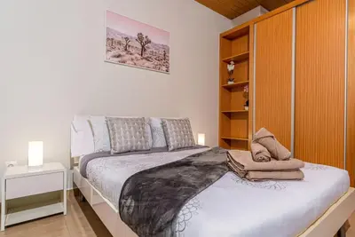a bedroom with a bed and a wooden cabinet at Marina View Apartment - Pool & stunning ocean view in Calheta