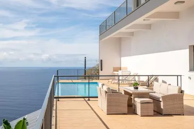 a balcony with a view of the ocean at Marina View Apartment - Pool & stunning ocean view in Calheta