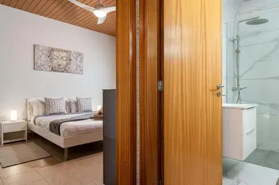 a bedroom with a bed and a bathroom with a shower at Marina View Apartment - Pool & stunning ocean view in Calheta