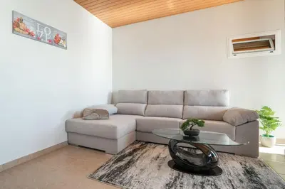 a living room with a couch and a table at Marina View Apartment - Pool & stunning ocean view in Calheta