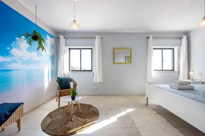 a bedroom with a bed and a table and a chair at Bay View Townhouse in Salema