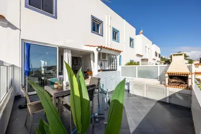 a balcony with a table and chairs on a building at Bay View Townhouse in Salema