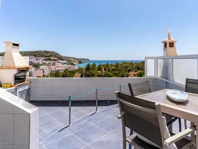 a balcony with a table and a view of the ocean at Bay View Townhouse in Salema