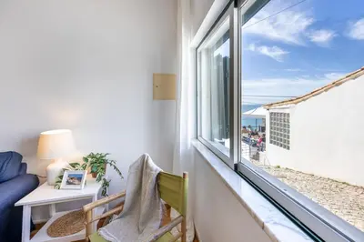 a room with a window looking out at the ocean at Villa som das Ondas in Budens