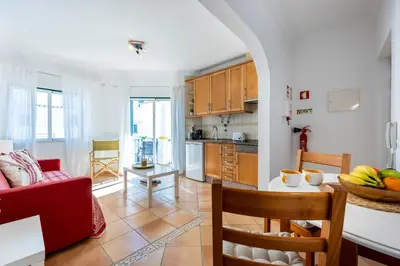 a kitchen and a living room with a red couch at Villa som das Ondas in Budens