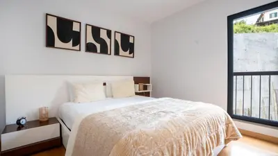 a white bedroom with a bed and a window at Deluxe Living by LovelyStay in Funchal