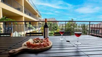 a table with two glasses of wine and a plate of food at Deluxe Living by LovelyStay in Funchal