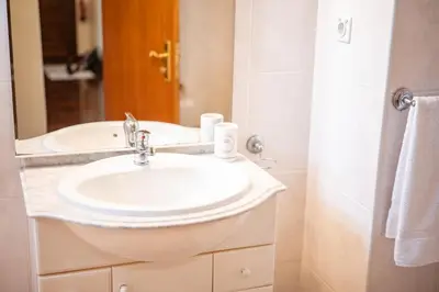 a bathroom with a white sink and a mirror at Apartamento Vista Azul in Funchal