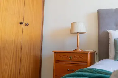 a bedroom with a bed and a lamp on a dresser at Apartamento Vista Azul in Funchal
