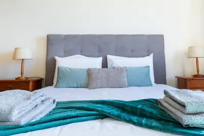 a bed with a green blanket on top of it at Apartamento Vista Azul in Funchal