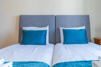 two beds with blue pillows sitting next to each other at Apartamento Vista Azul in Funchal
