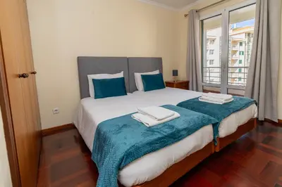 a bedroom with a large bed with blue pillows at Apartamento Vista Azul in Funchal