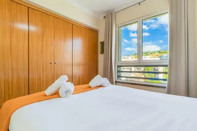 a bedroom with a large white bed and a window at Monumental Ocean View by Atlantic Holiday in Funchal