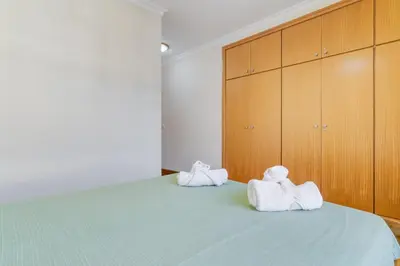 two towels on a bed in a room with wooden cabinets at Monumental Ocean View by Atlantic Holiday in Funchal