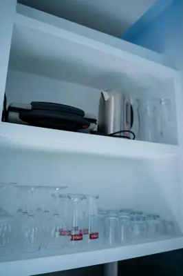 a white shelf with glasses on it at Majestic Seaview Villa in Fajã da Ovelha