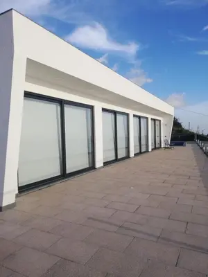a large white building with large windows on it at Majestic Seaview Villa in Fajã da Ovelha