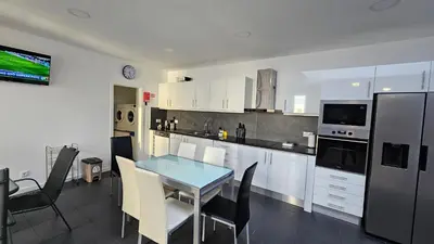 a kitchen with a table and chairs in a room at Majestic Seaview Villa in Fajã da Ovelha