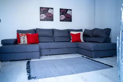 a living room with a blue couch with red pillows at Majestic Seaview Villa in Fajã da Ovelha