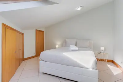 a white bedroom with a white bed in a room at Camara de Lobos Duplex Apartment by Holiday Rental Madeira in Câmara de Lobos