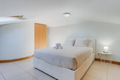 a white bedroom with a bed in a room at Camara de Lobos Duplex Apartment by Holiday Rental Madeira in Câmara de Lobos