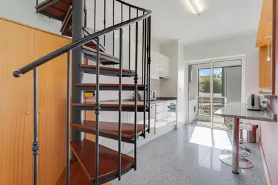 a kitchen with a spiral staircase in a house at Camara de Lobos Duplex Apartment by Holiday Rental Madeira in Câmara de Lobos