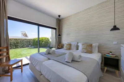 a bedroom with a large bed and a large window at Villa Back Loop in Sagres