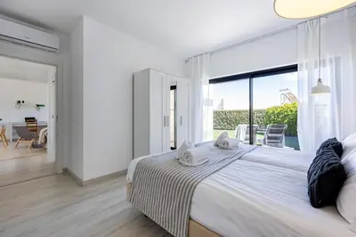a bedroom with a large bed and a large window at Villa Back Loop in Sagres