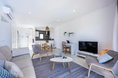 a living room with a couch and a tv at Villa Back Loop in Sagres